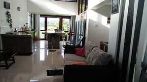 Amplia sala de estar con sofá, mesa de comedor y zona de cocina.