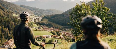 Paisagem de montanha com uma ponte e edifícios no vale.