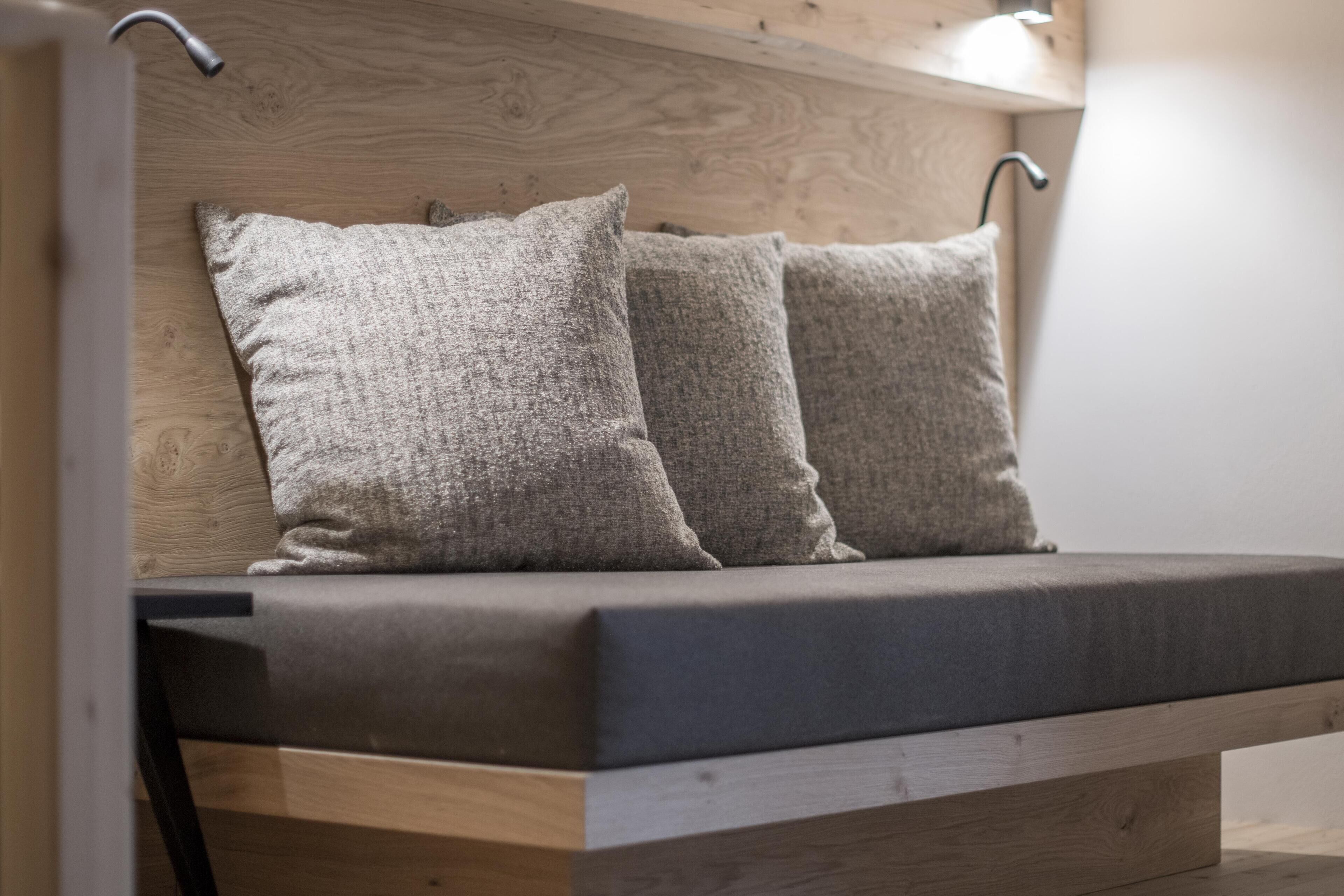 Un banco de madera con cojines y estructura metálica.