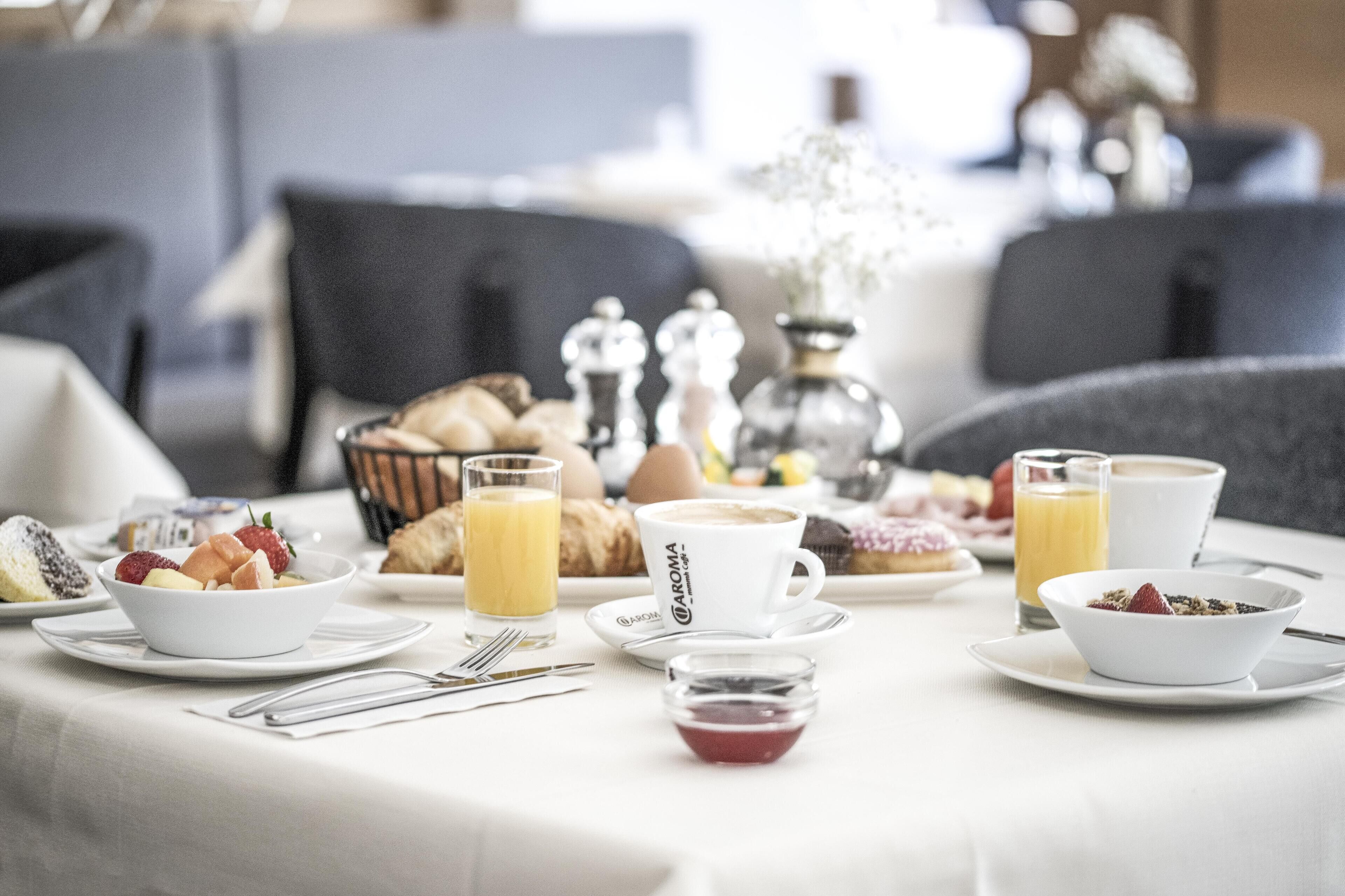A breakfast setting with a variety of food items and beverages on a table.