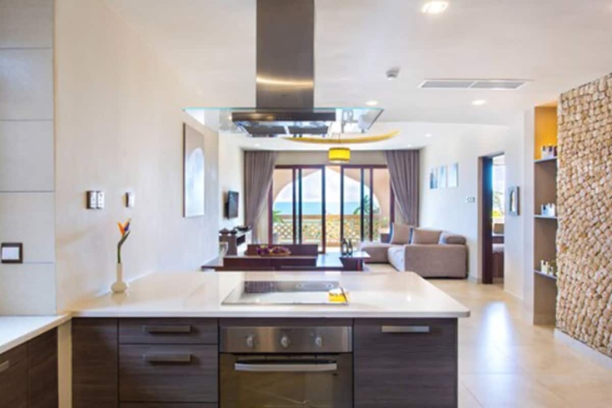 A modern kitchen with a central island, built-in appliances, and a view to the outside.