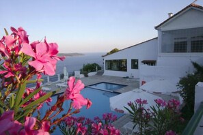 A modern white building with a swimming pool and a view of the sea. - Skiathos Club Hotel Suites (Skiathos)