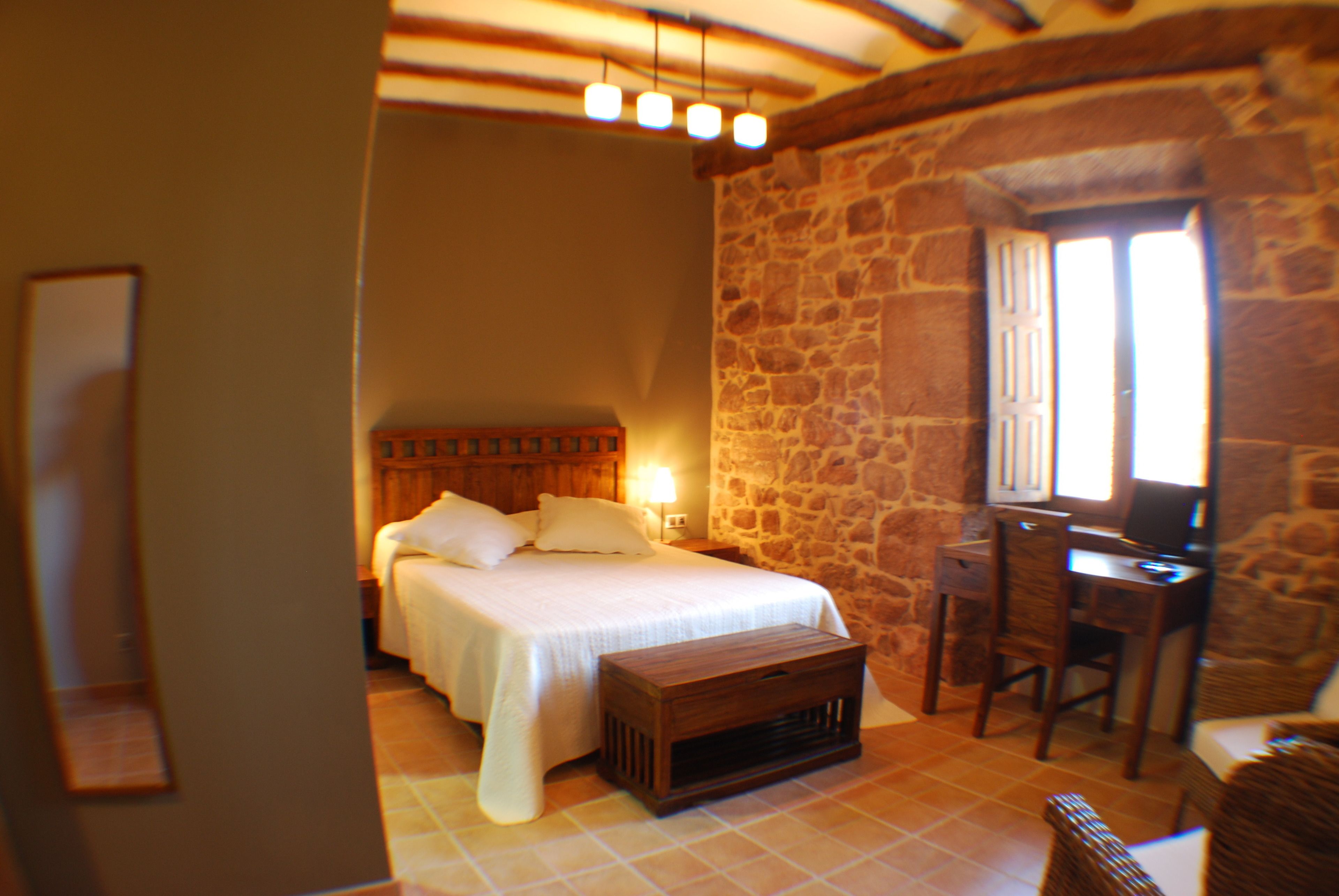 Ein Schlafzimmer mit Bett, Nachttisch und Schreibtisch mit Stuhl.