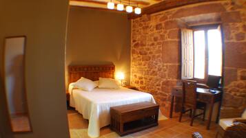 Ein Schlafzimmer mit Bett, Nachttisch und Schreibtisch mit Stuhl.