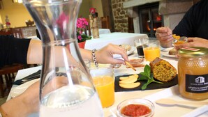 A dining table with food, drinks, and a glass pitcher. - Hostal Rural Ioar (Sorlada)