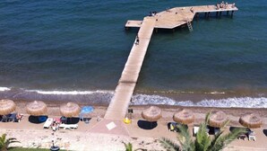 A pier extending into the sea with beach chairs and umbrellas. - Faustina Hotel & Spa (Kusadasi)