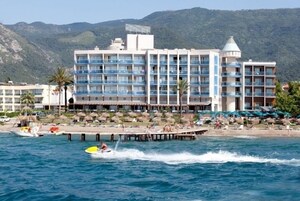 Un hotel con diversi balconi, un molo e una zona spiaggia.