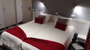 Una camera d'albergo con un letto, un comodino, una lampada e una porta.