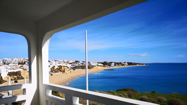 Un balcone con vista su una spiaggia e una cittadina costiera.