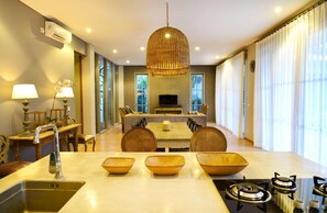 Un comedor moderno con una mesa central, sillas y una lámpara colgante.