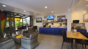 A modern hotel lobby with a dining area, bar, and seating arrangements. - Montha Hotel (Chiang Mai)
