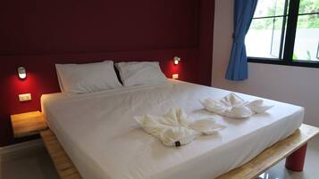 A neatly made bed with white linens and a wooden headboard.