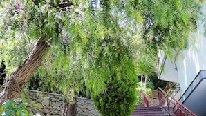 A staircase leading up to a building, surrounded by lush greenery and a stone wall. - Residence Green Park (Ventimiglia)