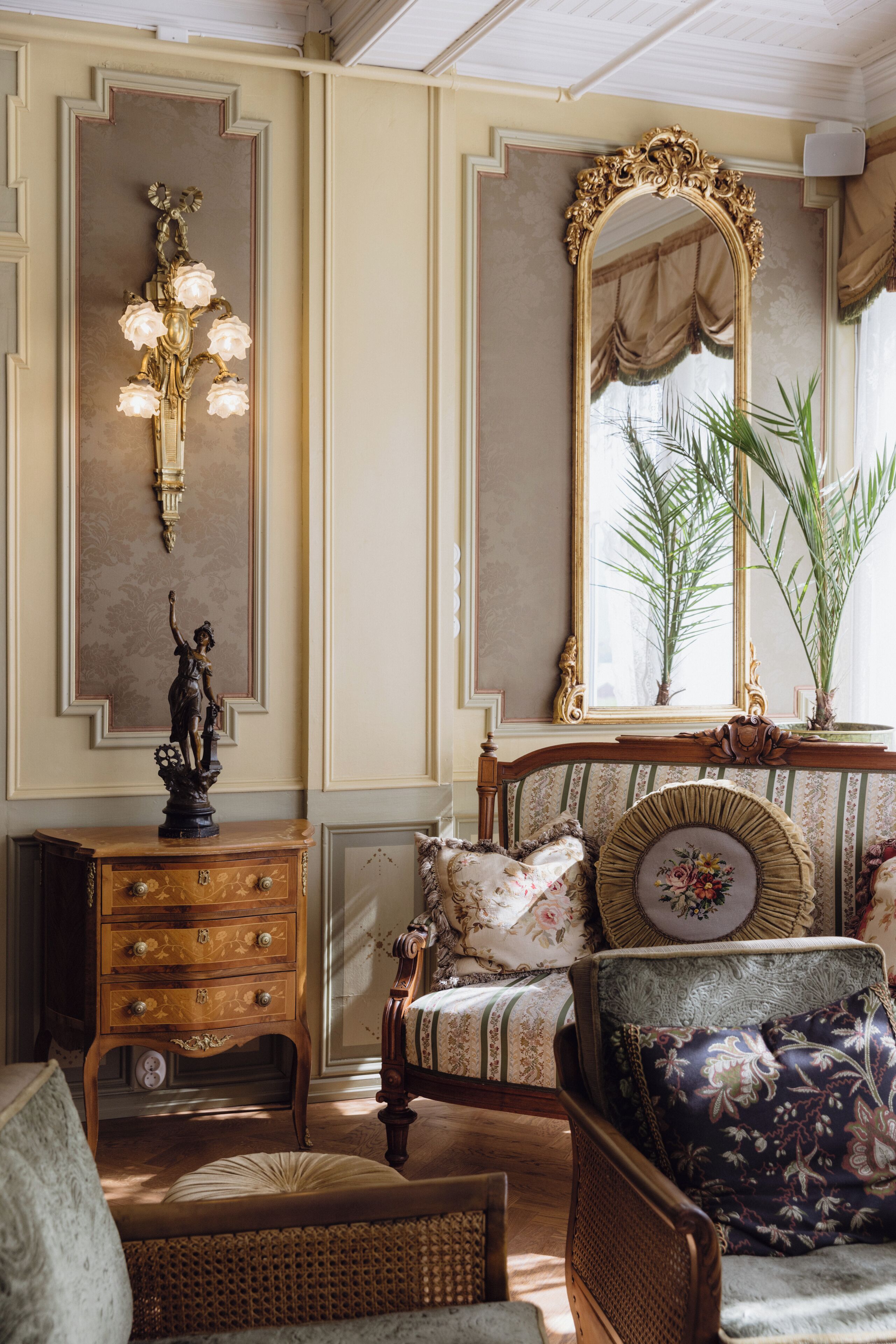 A room with a wooden dresser, a mirror, a lamp, and a chair.