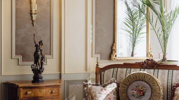 A room with a wooden dresser, a mirror, a lamp, and a chair.