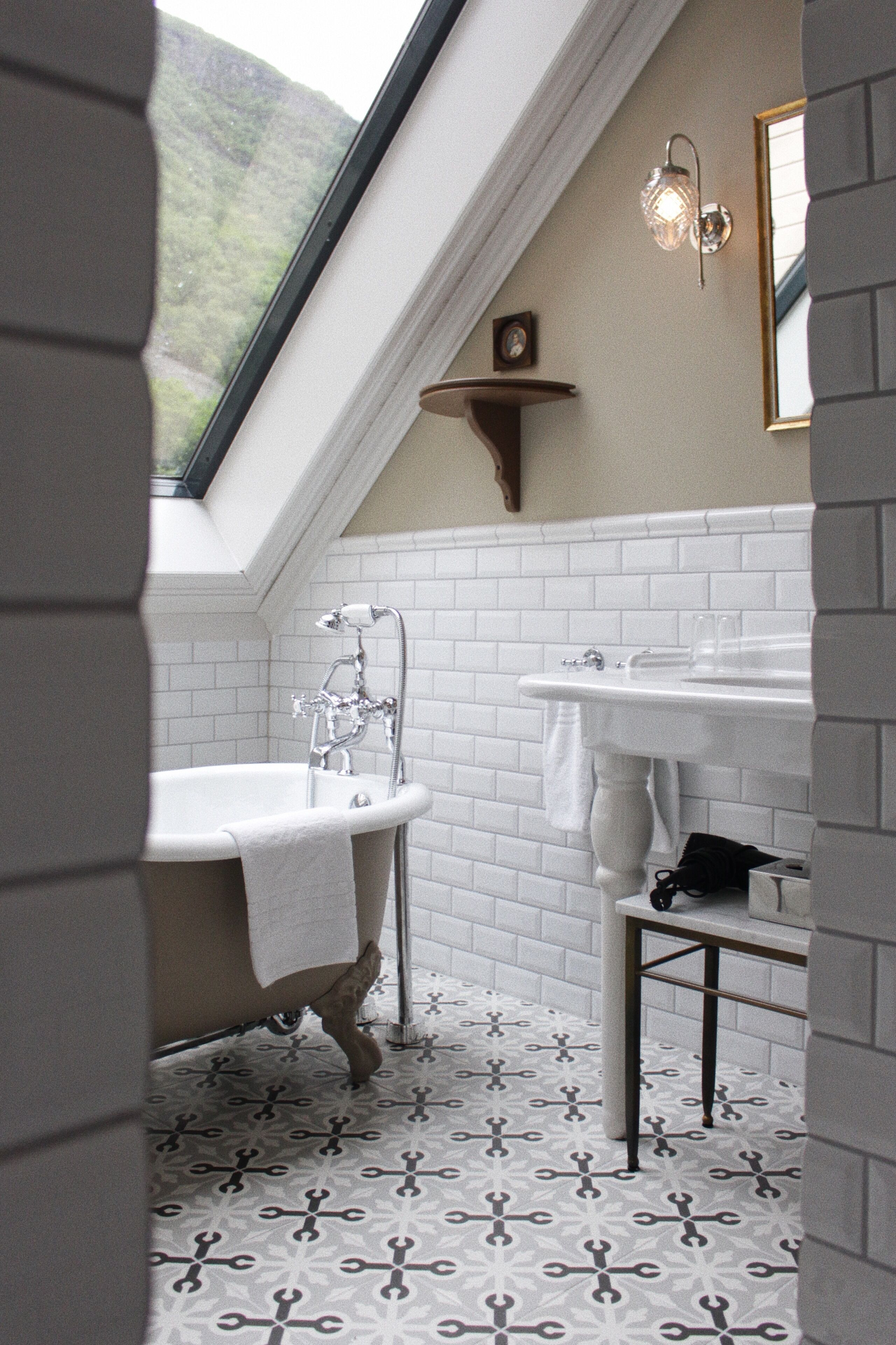A bathroom with a freestanding bathtub, a sink, and a mirror.