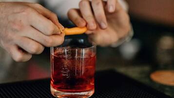 A person pouring a dark liquid from a bottle into a glass.