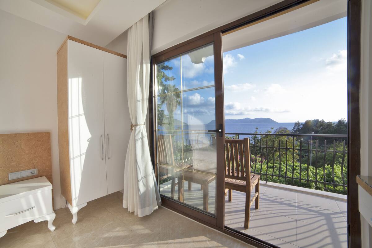 Un balcón con vista al mar y a las montañas.