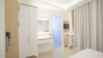 A hotel room with a bed, a desk, a mirror, a television, and a wardrobe.
