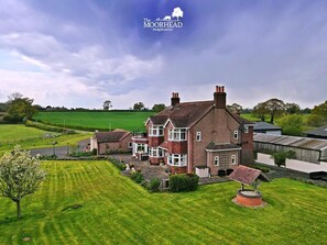 A large, two-story house with a well-maintained lawn and a small garden area. - The Moorhead Bed & Breakfast (Shrewsbury)