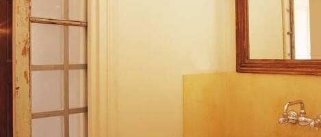 Un baño con un lavabo blanco, un espejo y un perchero para toallas.