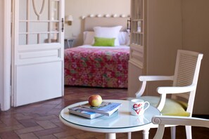 A room with a bed, a chair, a table with a book, a mug, and an apple. - Hotel Aiguaclara (Begur)
