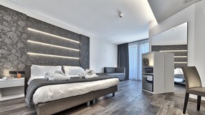 Un dormitorio moderno con una cama grande, mesitas de noche, televisor y armario.