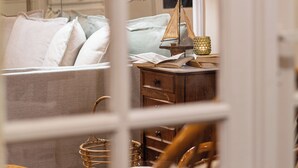Una habitación acogedora con cama, una silla de madera, un escritorio con lámpara y una estantería.