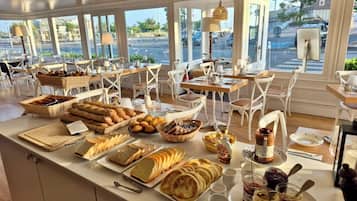 Un buffet de petit-déjeuner proposant une variété de pains, de viennoiseries et de tartinades.