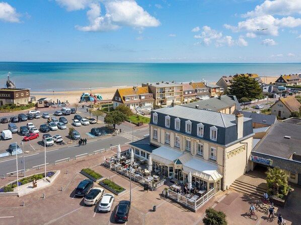 A hotel with a restaurant and outdoor seating, located near a beach.