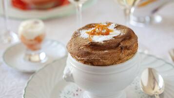 A dessert in a white cup on a plate with a spoon.