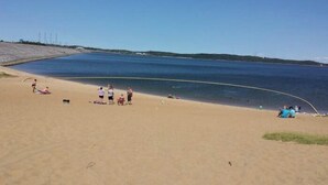 A beach with a sandy shore and a calm body of water. - Early American Motel (Hardin)
