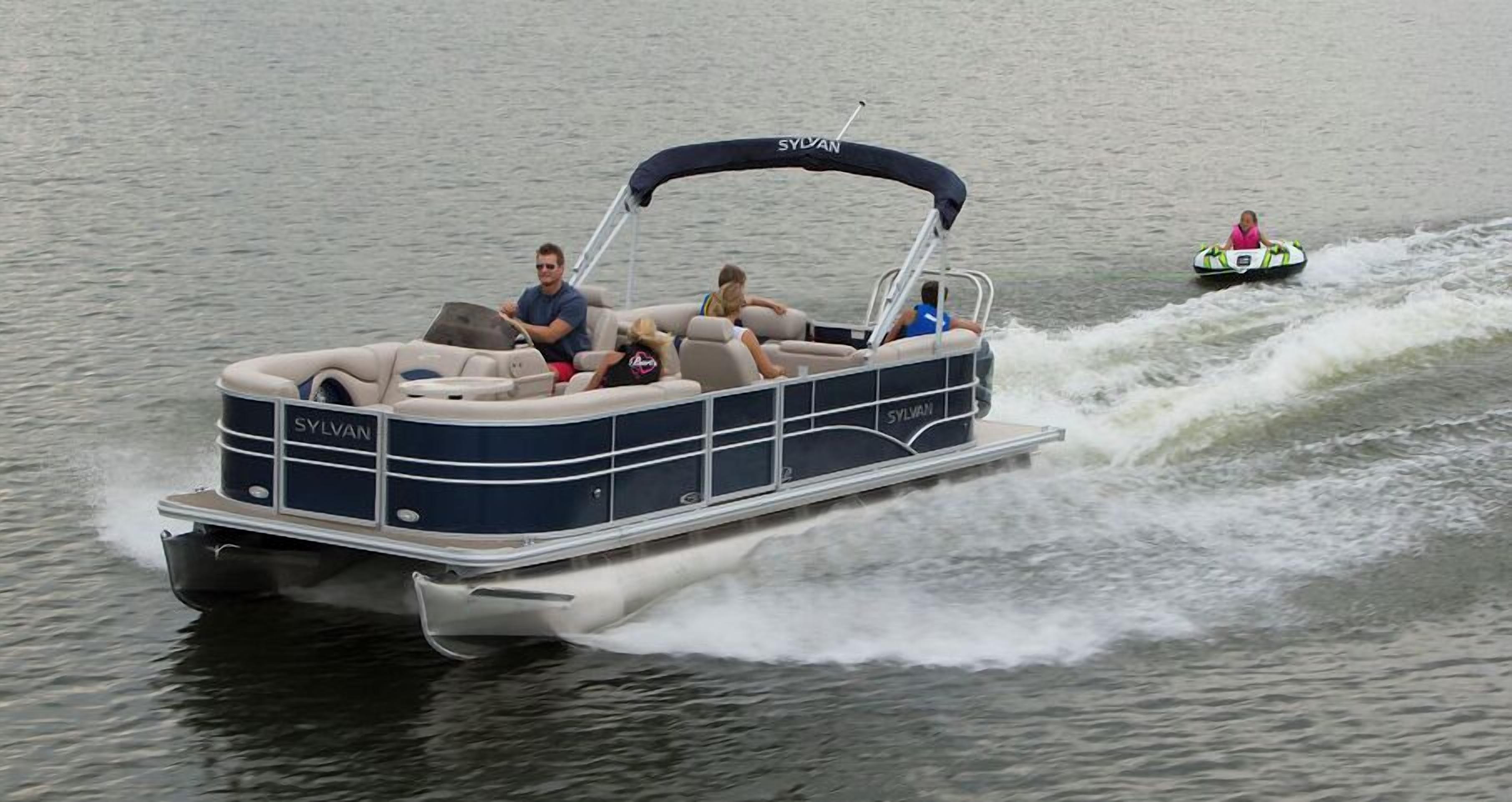 Een boot met de naam 'SYLVAN' op de zijkant, die over het water vaart.