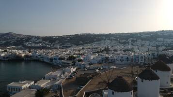 Un pueblo costero con edificios blancos, un puerto y molinos.