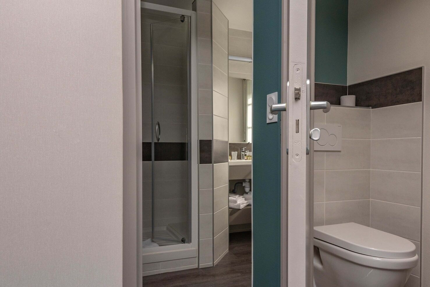 Ein modernes Badezimmer mit Duschkabine aus Glas, Toilette und Waschbecken.