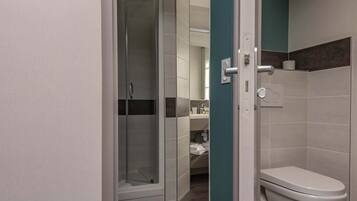Ein modernes Badezimmer mit Duschkabine aus Glas, Toilette und Waschbecken.