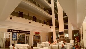 En rummelig lobby med flere siddeområder, en restaurant der hedder 'BAYAR', og en trappe til de øvre etager.