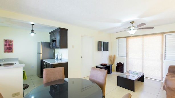 Un espace de vie compact comprenant un coin repas, une kitchenette et un ventilateur de plafond.