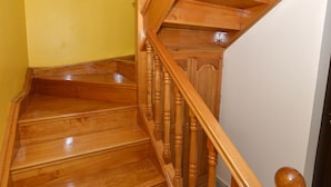 Una scala in legno con corrimano e pianerottolo.