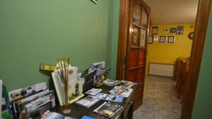 Una reception con brochure e un bicchiere d'acqua. Si vede una porta in legno e un termosifone sullo sfondo.