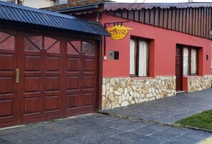 Un edificio con fachada roja, base de piedra y un letrero que dice "MISTEN KEPPEN BAR".
