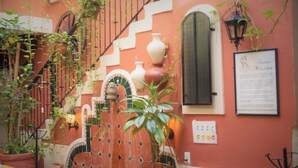 A traditional Spanish-style courtyard with a tiled fountain, potted plants, and a staircase. - Hotel Belmar (Isla Mujeres)