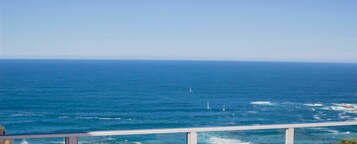 A view of the ocean from a balcony with a railing.