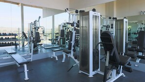 A gym with various exercise machines, benches, and dumbbells. - Casa Andina Standard Talara (Pariñas)