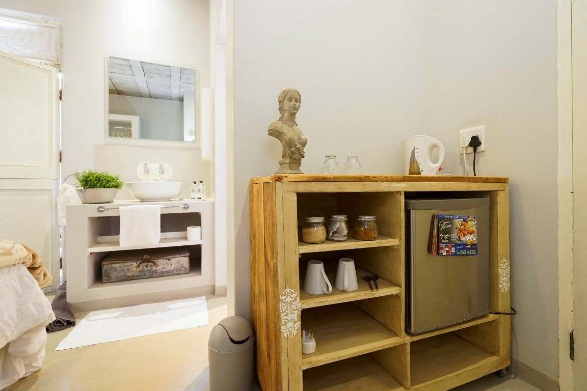 Una cocina compacta con un mueble de madera, un refrigerador y un lavamanos pequeño.