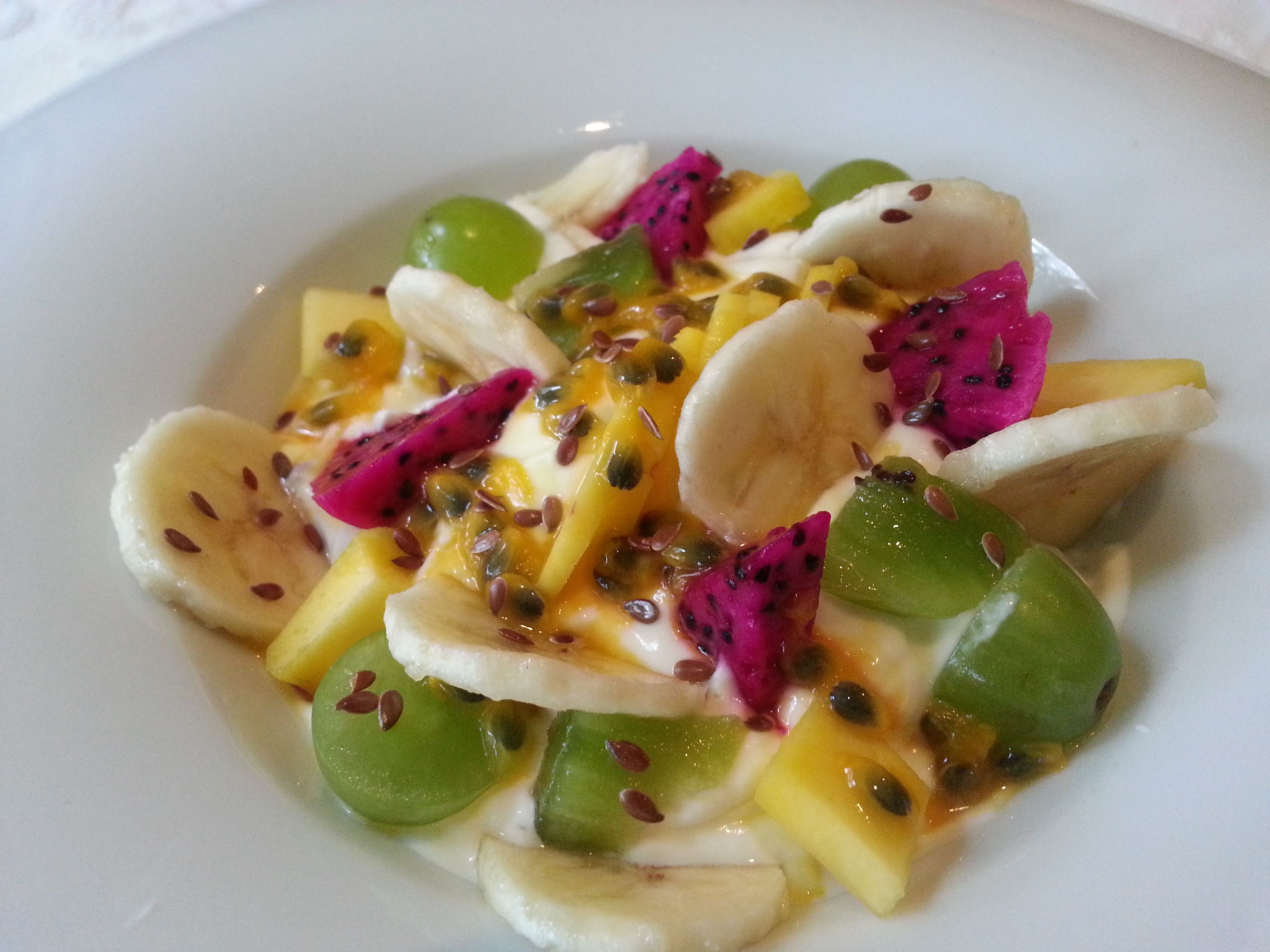 A plate of fruit salad with various fruits and seeds.