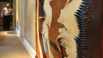 A hallway with a large wall mural featuring indigenous art.