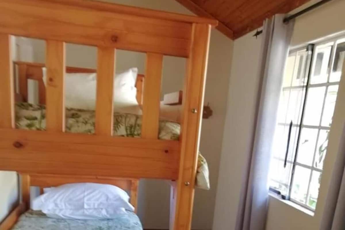 A bunk bed with a wooden frame and floral bedding.