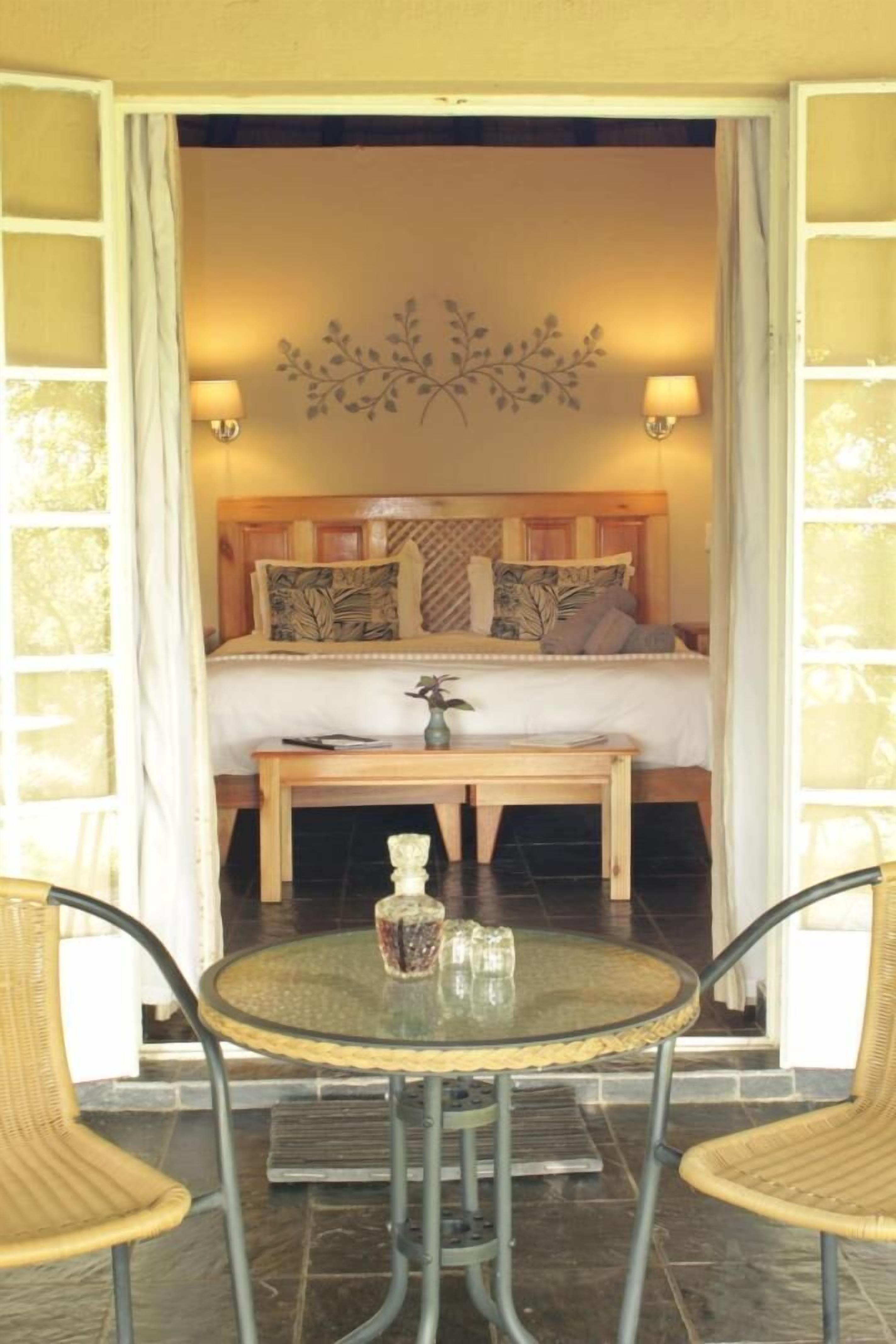 A bedroom with a bed, bedside table, lamp, and decorative wall art.