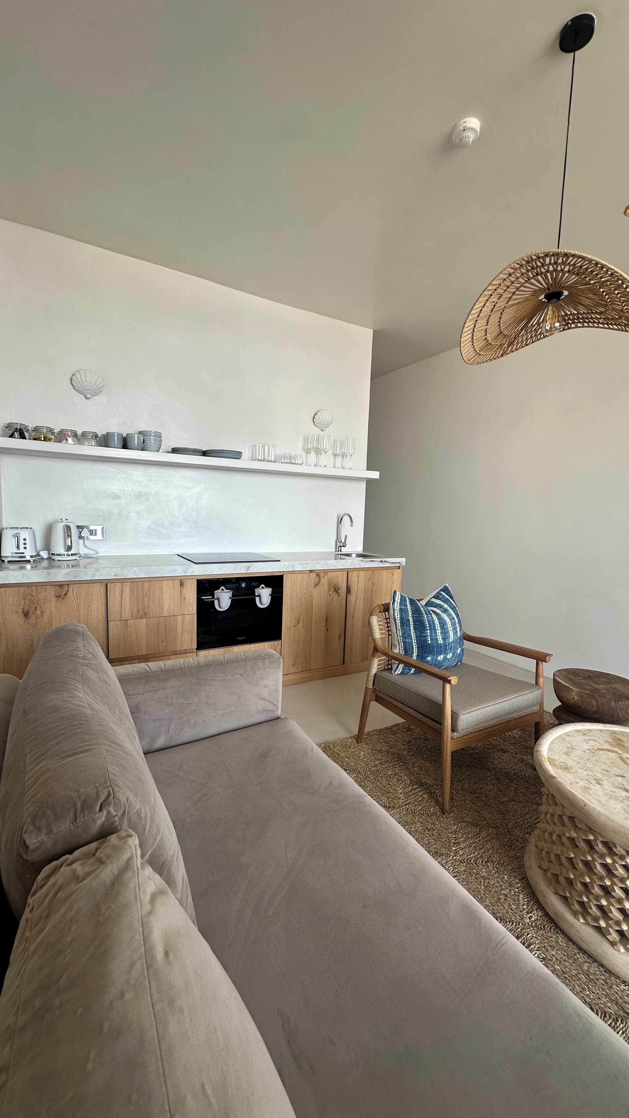 A modern kitchen with a built-in oven, a wooden cabinet, and a white countertop.